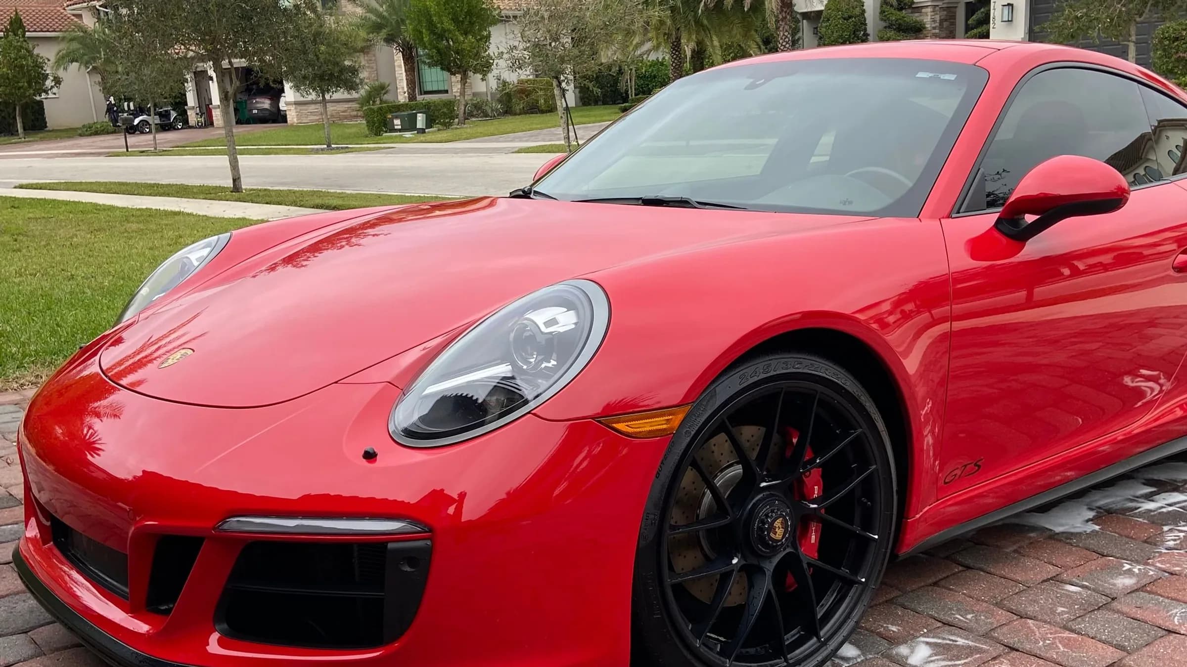 A red Porsche 911 GTS after a full mobile detail, paint gloss-corrected and wheels cleaned